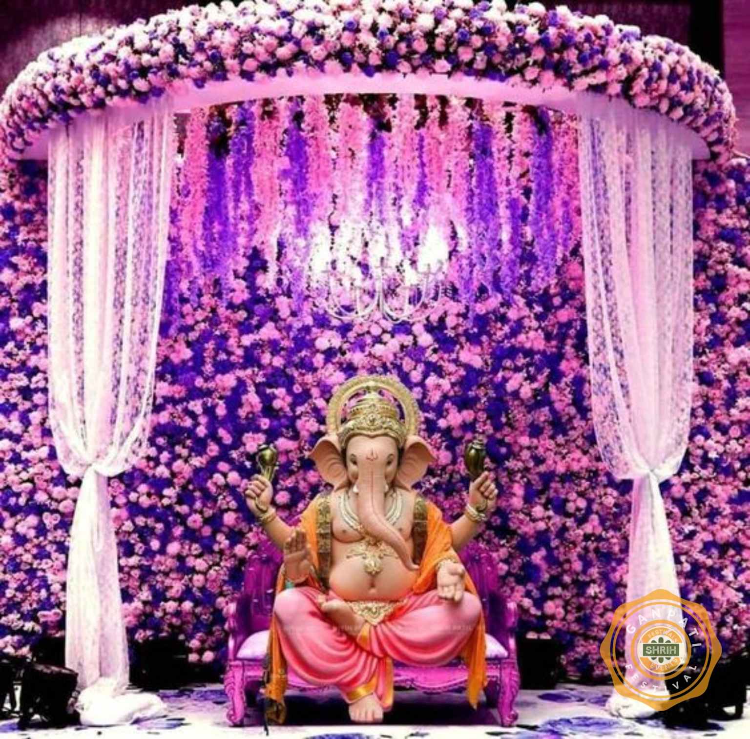 Vibrant pink and purple floral pandal decoration with Ganesha statue for Ganesh Chaturthi festival celebration