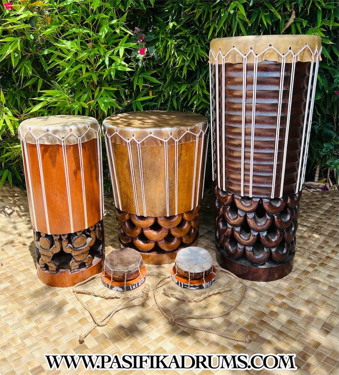 Traditional Hawaiian pahu drums displayed outdoors with intricate carvings and natural materials, essential in hula music and dance